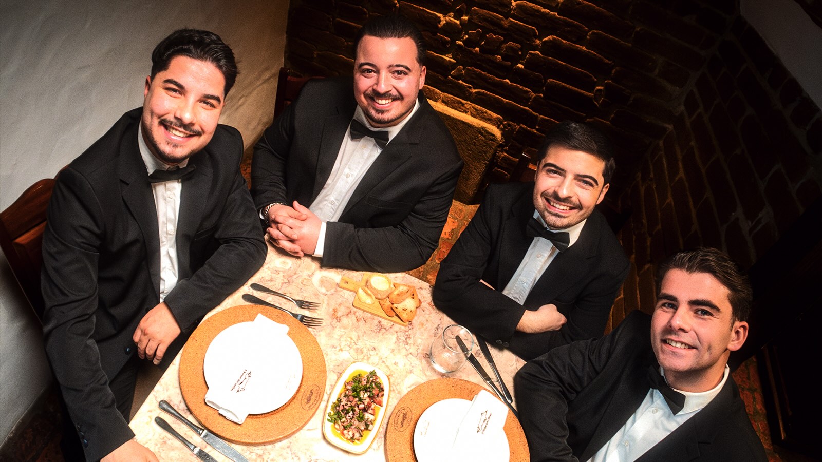 Os Vizinhos reunidos à mesa no videoclipe da música “Vizinha do 1º Andar”