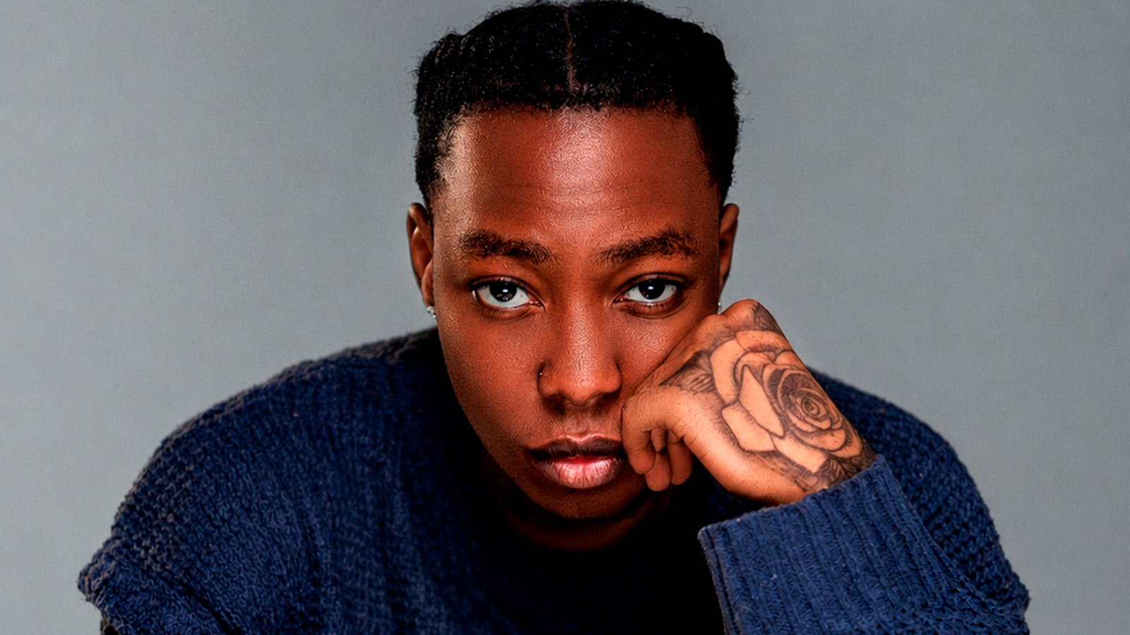 Young man facing the camera with defying look with hands at their chest level